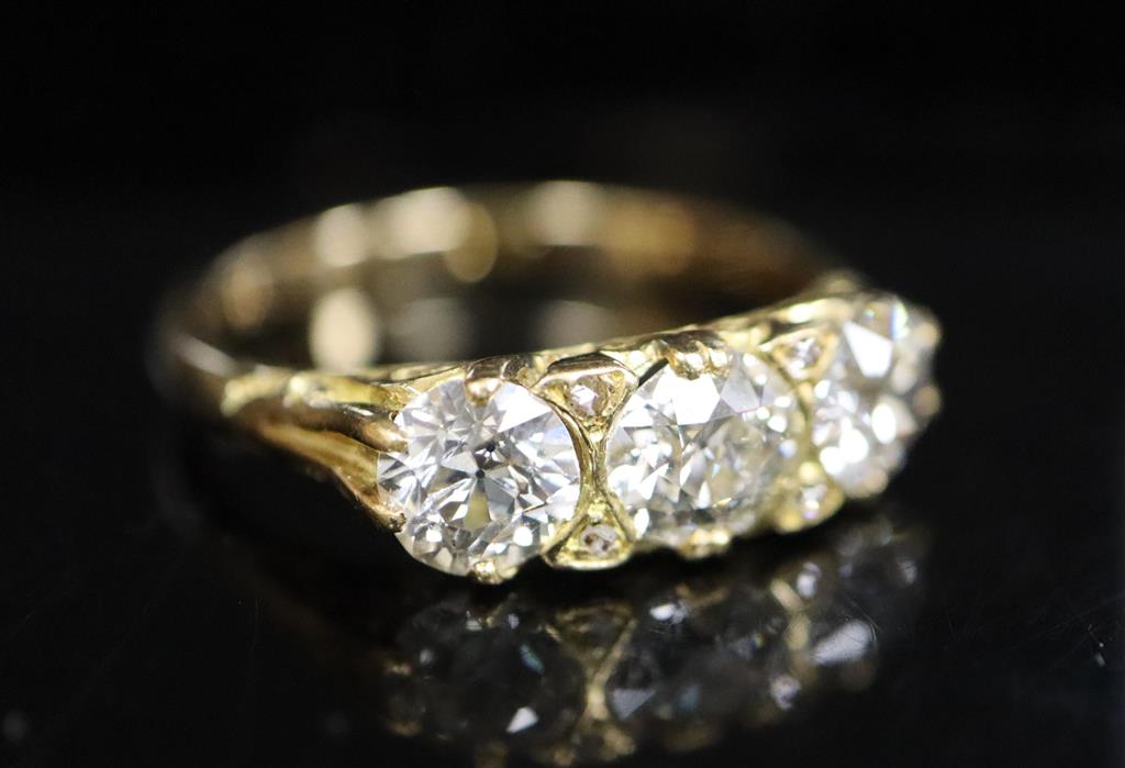 A Victorian style yellow metal and three stone diamond ring with diamond chip spacers, size Q, gross 4.5 grams.